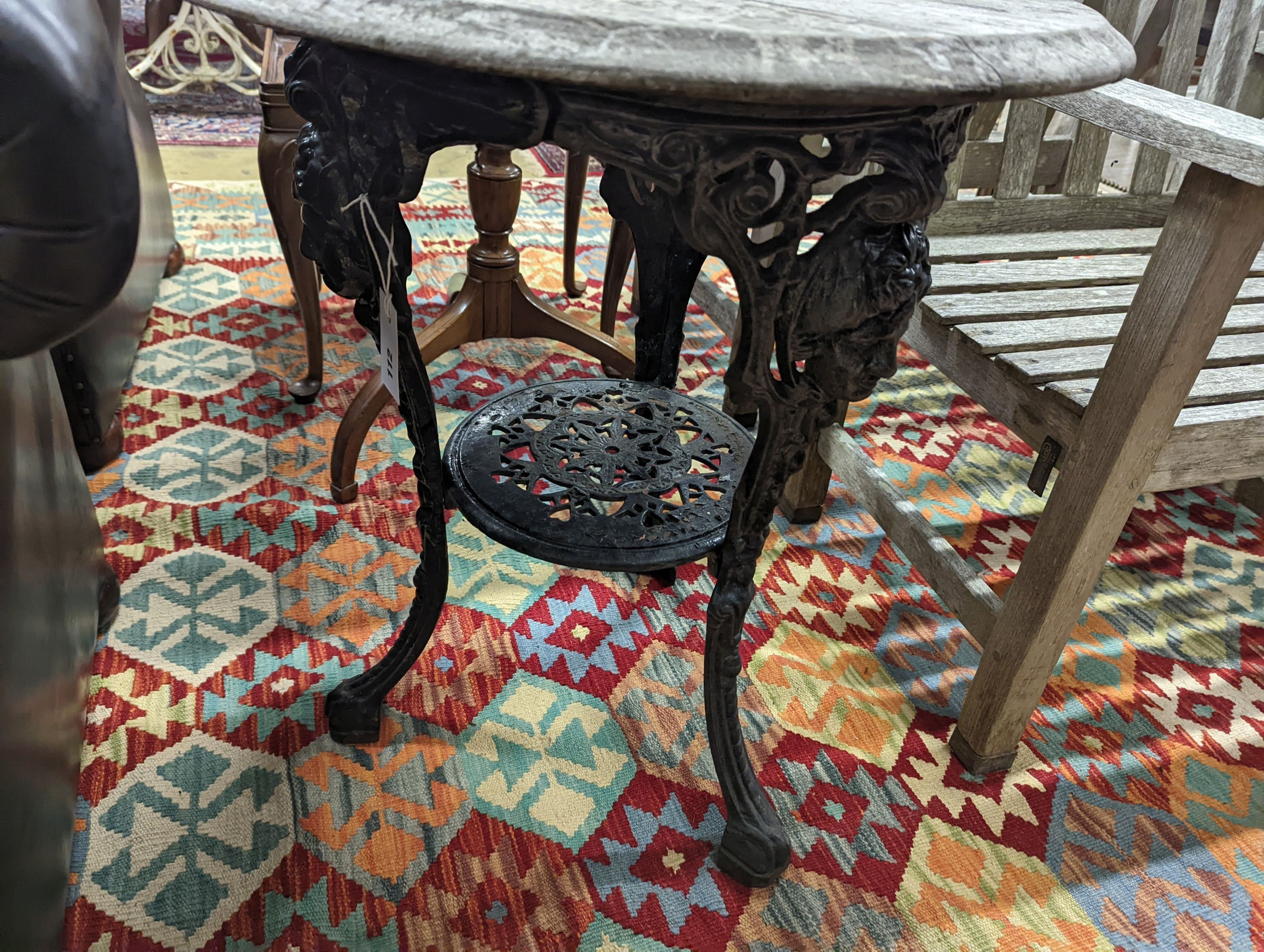 A Victorian cast iron Britannia table with circular weathered wood top, diameter 58cm, height 69cm